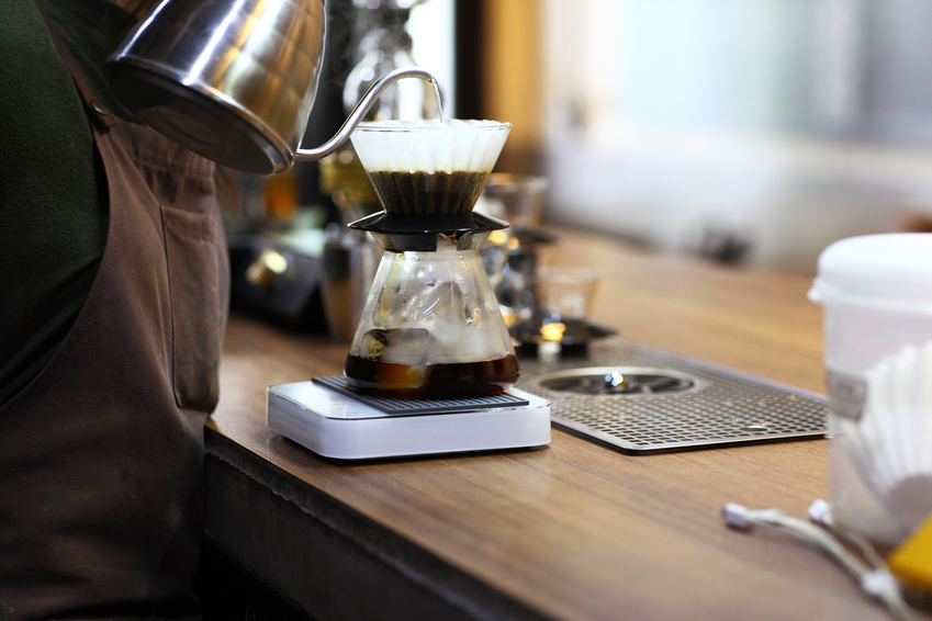 Barista making drip coffee on wood desk